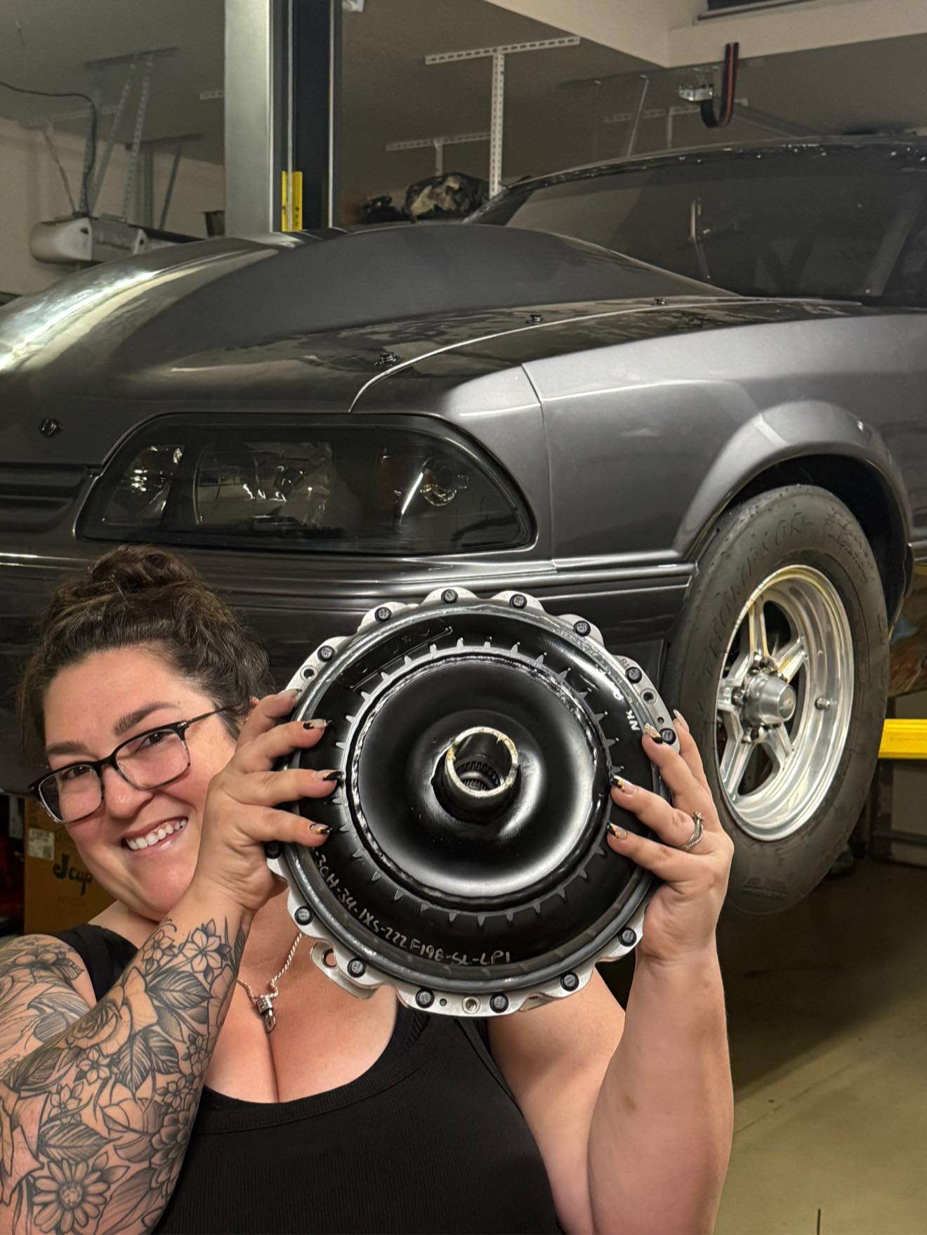 Amanda holding the converter in front of the Foxbody